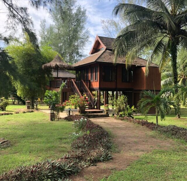 Brown Wooden House in the Middle of Grass Field